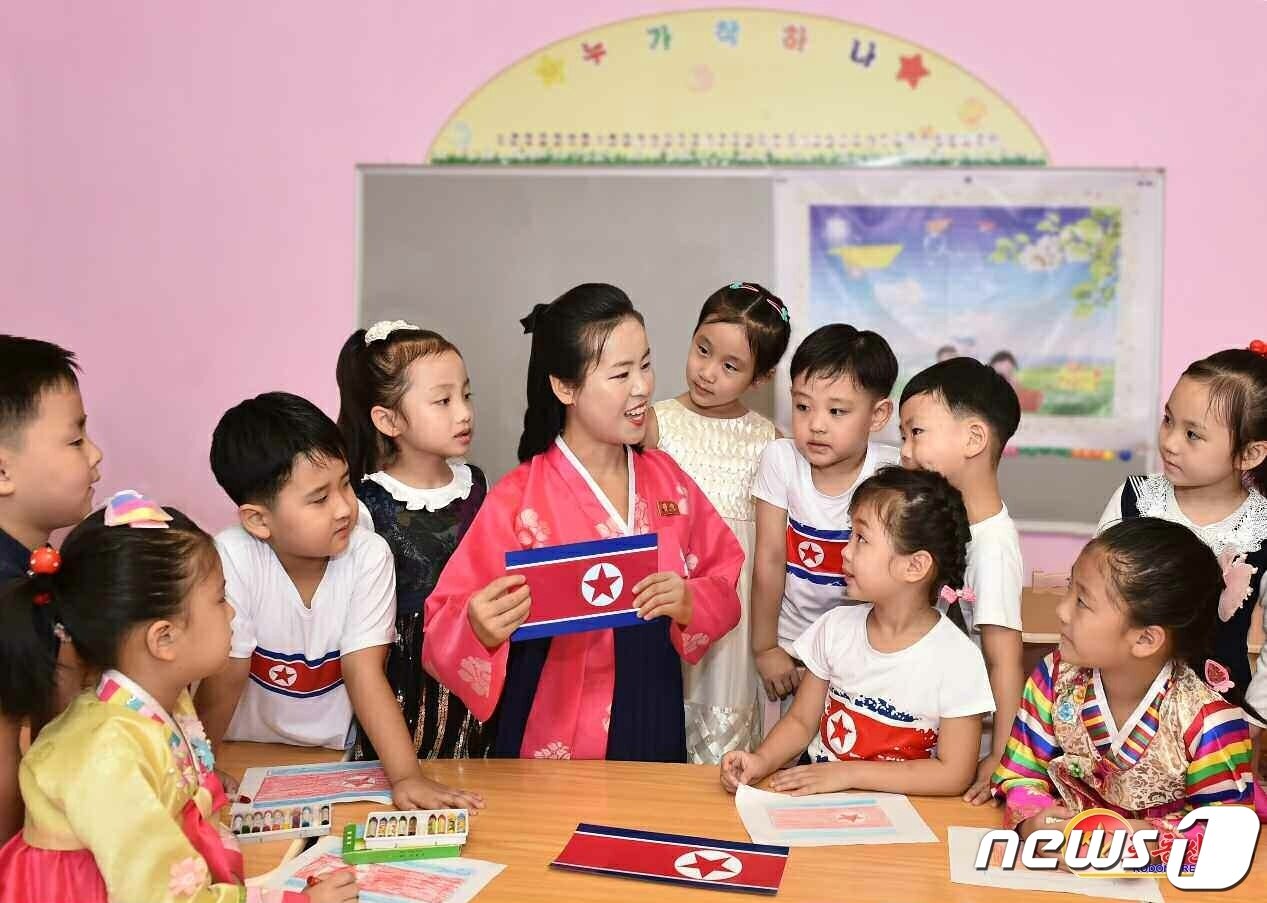 본문 이미지 - (평양 노동신문=뉴스1) = 인공기에 대한 설명을 듣고 있는 북한 유치원 어린이들. [국내에서만 사용가능. 재배포 금지. DB 금지. For Use Only in the Republic of Korea. Redistribution Prohibited] rodongphoto@news1.kr