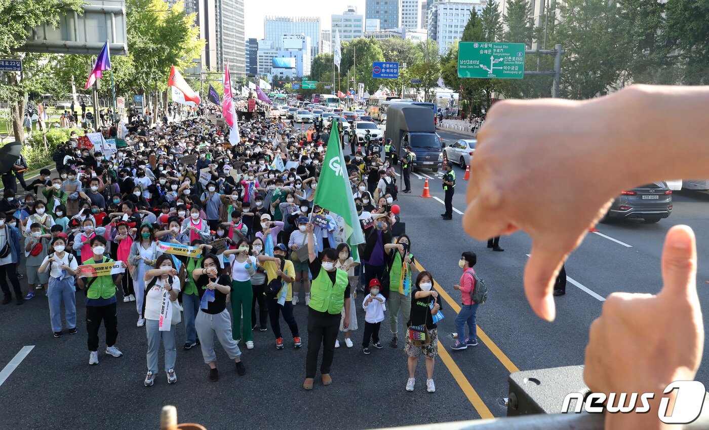 본문 이미지 - 924 기후정의행진 참가자들이 24일 서울시청 인근 세종대로에서 화석 연료와 생명 파괴 체제 종식을 촉구하던 중 기후의 의미가 담긴 수어를 배워보고 있다. 이날 주최측은 행진에 3만 5천 명의 시민이 함께했다고 전했다. 2022.9.24/뉴스1 ⓒ News1 조태형 기자