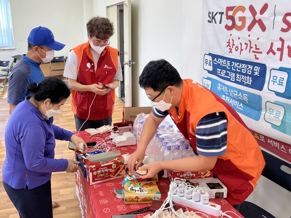 본문 이미지 - SK텔레콤 직원들이 포항시 남구 대송면 다목적복지관 대피소에서 무료 스마트폰 충전 서비스를 제공하고 있다. (SKT 제공)