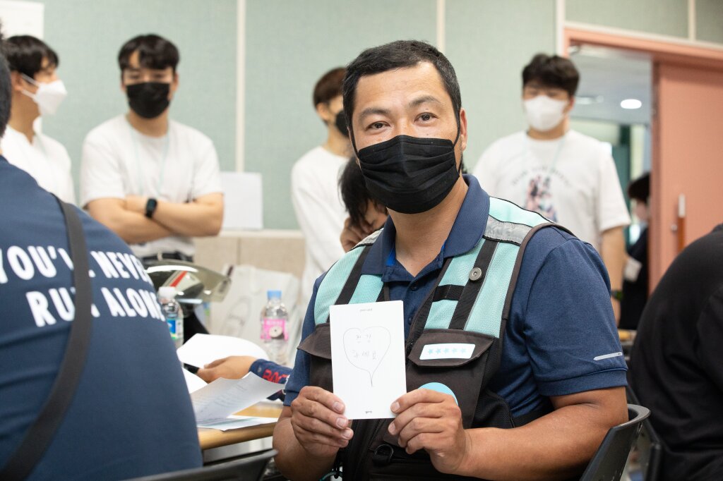본문 이미지 -  나눔 활동에 참여한 배달의민족 라이더가 엽서를 들고 있다.&#40;우아한형제들 제공&#41;