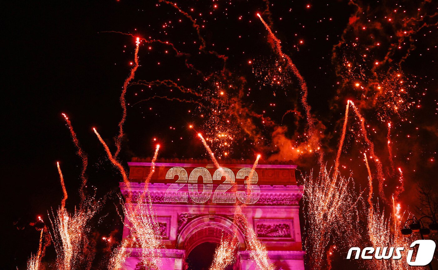 본문 이미지 - 1일(현지시간) 0시 정각 프랑스 파리에서 2023년 새해를 축하하는 붉은색 불꽃이 개선문 주변을 수놓고 있다. 2023.1.1. ⓒ 로이터=뉴스1 ⓒ News1 김성식 기자