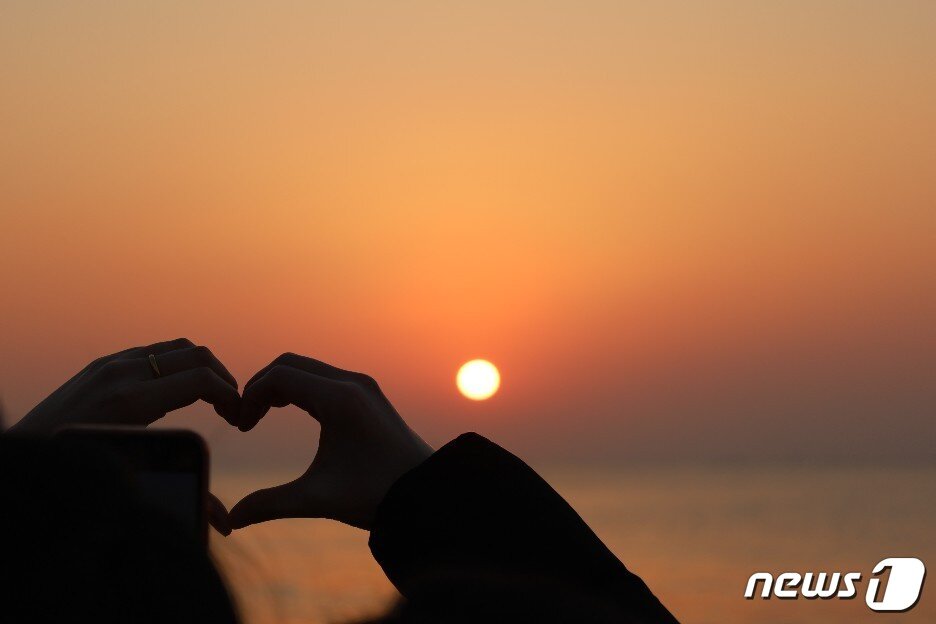 본문 이미지 - 1일 오전 부산 해운대해수욕장에서 연인이 일출을 보며 손하트를 그리고 있다. 2023.1.1. 손연우 기자