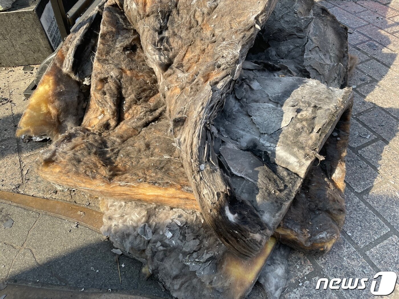 본문 이미지 - 지난 9일 오전 부산 부산진구 서면 오피스텔 주차타워 화재 현장에서 발견된 단열재 '글라스울'이 검게 그을려 있다.2023.1.9/뉴스1 강승우 기자