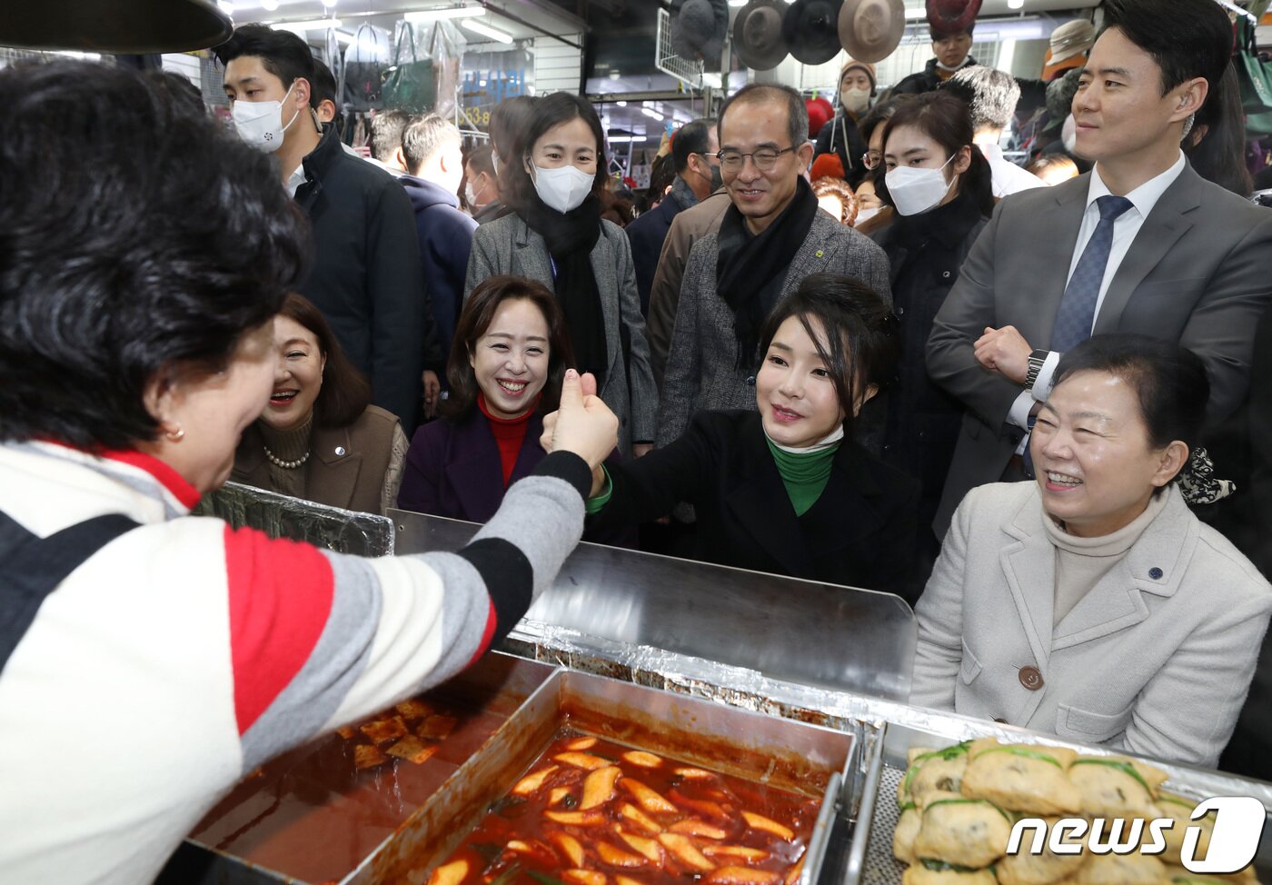 본문 이미지 - 윤석열 대통령의 부인 김건희 여사가 11일 오후 대구 중구 서문시장을 찾아 떡볶이 등 음식을 맛보며 다시 방문할 것을 상인과 약속하고 있다. 2023.1.11/뉴스1 ⓒ News1 공정식 기자