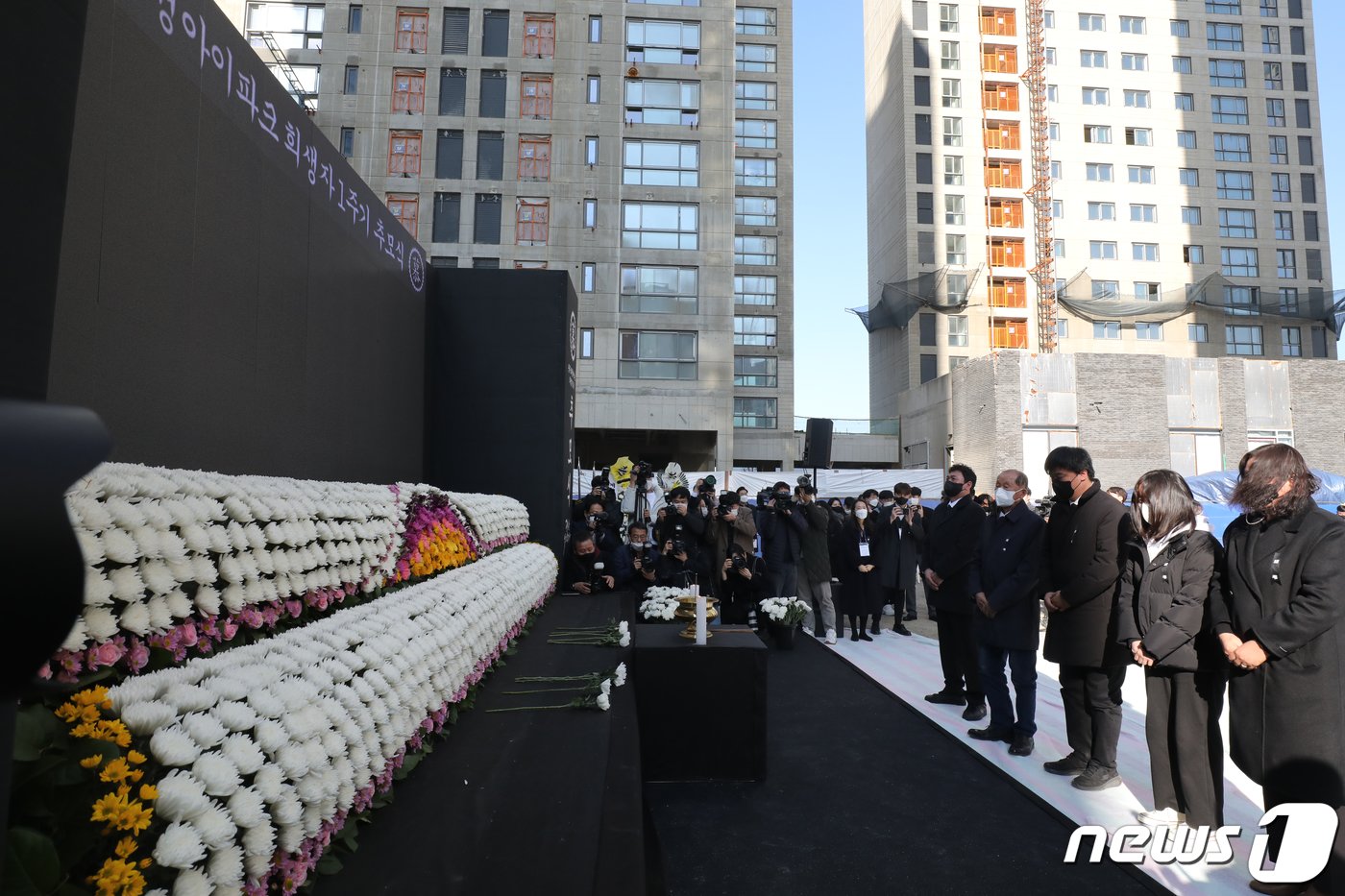 지난 2023년 1월 11일 근로자 6명의 목숨을 앗아간 광주 서구 화정동 현대산업개발 아파트 신축공사 붕괴사고 현장에서 열린 1주기 추모식에서 유족들이 헌화하고 있다. 2023.1.11/뉴스1