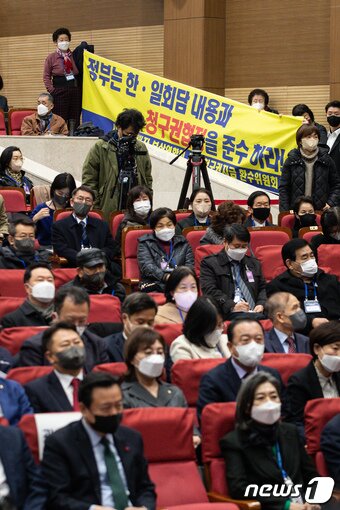 본문 이미지 - 12일 서울 여의도 국회 의원회관에서 열린 강제징용 해법 논의를 위한 공개토론회에서 참석자들이 한일 청구권협정 준수 촉구 현수막을 들고 있다. 2023.1.12/뉴스1 ⓒ News1 유승관 기자