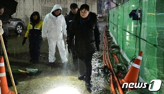 최문순 화천군수를 비롯한 군청직원들이 13일 새벽 화천산천어축제장 주변에서 빗물제거 작업을 펼치고 있다.&#40;화천군 제공&#41; 2023.1.13/뉴스1