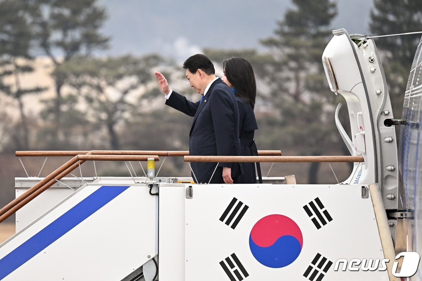 본문 이미지 - 윤석열 대통령과 김건희 여사가 14일 경기 성남 서울공항에서 아랍에미리트&#40;UAE&#41; 국빈 방문·다보스포럼 6박 8일간의 순방을 위해 공군 1호기에 올라 손을 흔들고 있다. &#40;대통령실 제공&#41; 2023.1.14/뉴스1 ⓒ News1 안은나 기자