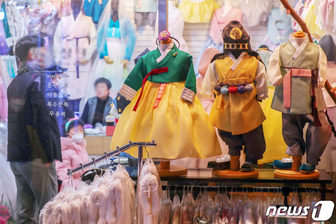 본문 이미지 - 설 명절을 일주일 앞둔 15일 서울 종로구 광장시장 한복상가에서 시민들이 자녀들이 입을 한복을 고르고 있다. 2023.1.15/뉴스1 ⓒ News1 민경석 기자