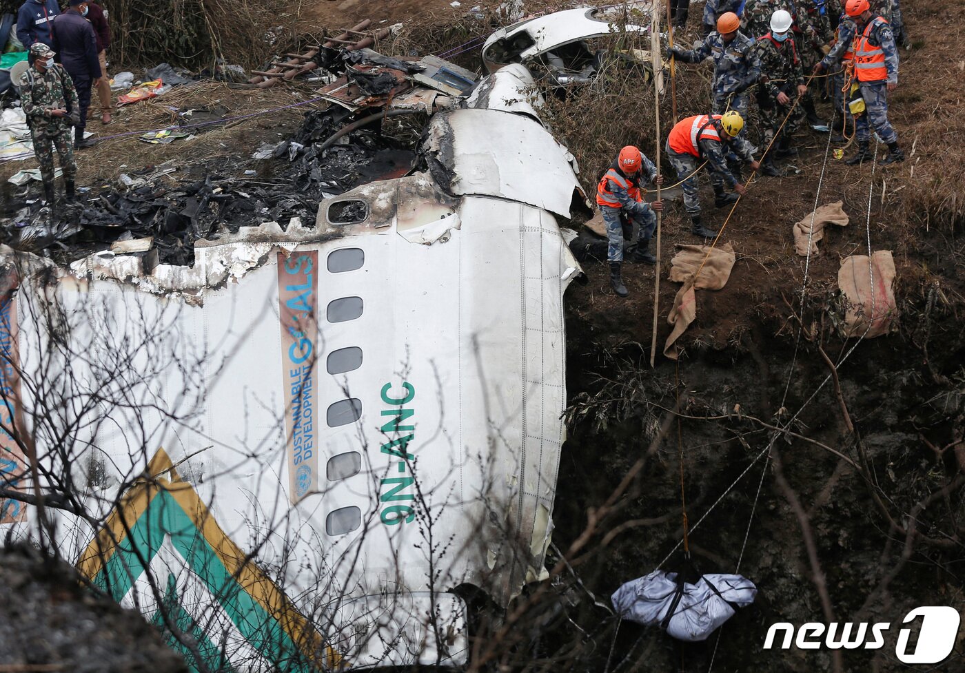 본문 이미지 - 16일(현지시간) 비행기 추락 사고가 발생한 네팔 포카라에서 발견한 시신을 구조대가 끌어올리고 있다. 총 72명이 탑승했던 이 비행기에서 현재까지 생존자는 나오지 않았다. 네팔 정부는 사고 원인을 규명하는 위원회를 구성하고 45일 내로 결과를 발표하겠다고 밝혔다. ⓒ 로이터=뉴스1 ⓒ News1 권진영 기자
