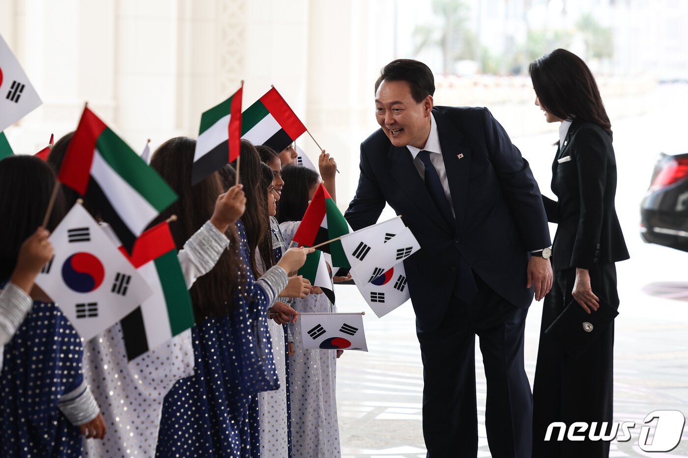 본문 이미지 - 윤석열 대통령과 김건희 여사가 15일 오전(현지시간) 아랍에미리트(UAE) 아부다비 카사르 알 와탄에서 열린 공식 환영식에 참석해 양국 국기를 든 어린이들과 인사를 나누고 있다. (대통령실 제공) 2023.1.16/뉴스1 ⓒ News1 안은나 기자