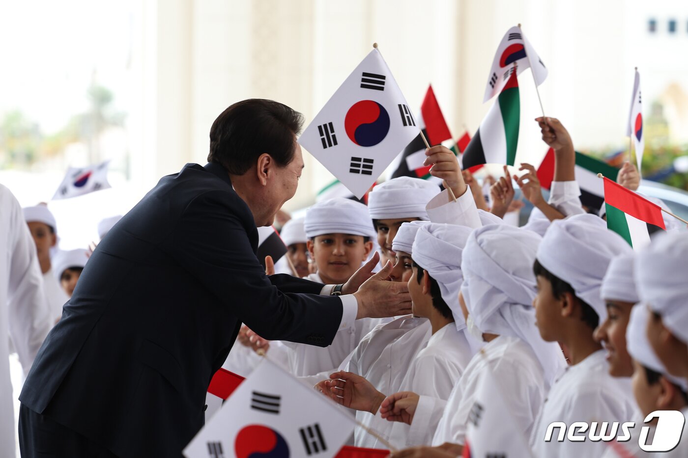본문 이미지 - 윤석열 대통령이 15일 오전(현지시간) 아랍에미리트(UAE) 아부다비 카사르 알 와탄에서 열린 공식 환영식에 참석해 양국 국기를 든 어린이들과 인사를 나누고 있다. (대통령실 제공) 2023.1.16/뉴스1 ⓒ News1 안은나 기자