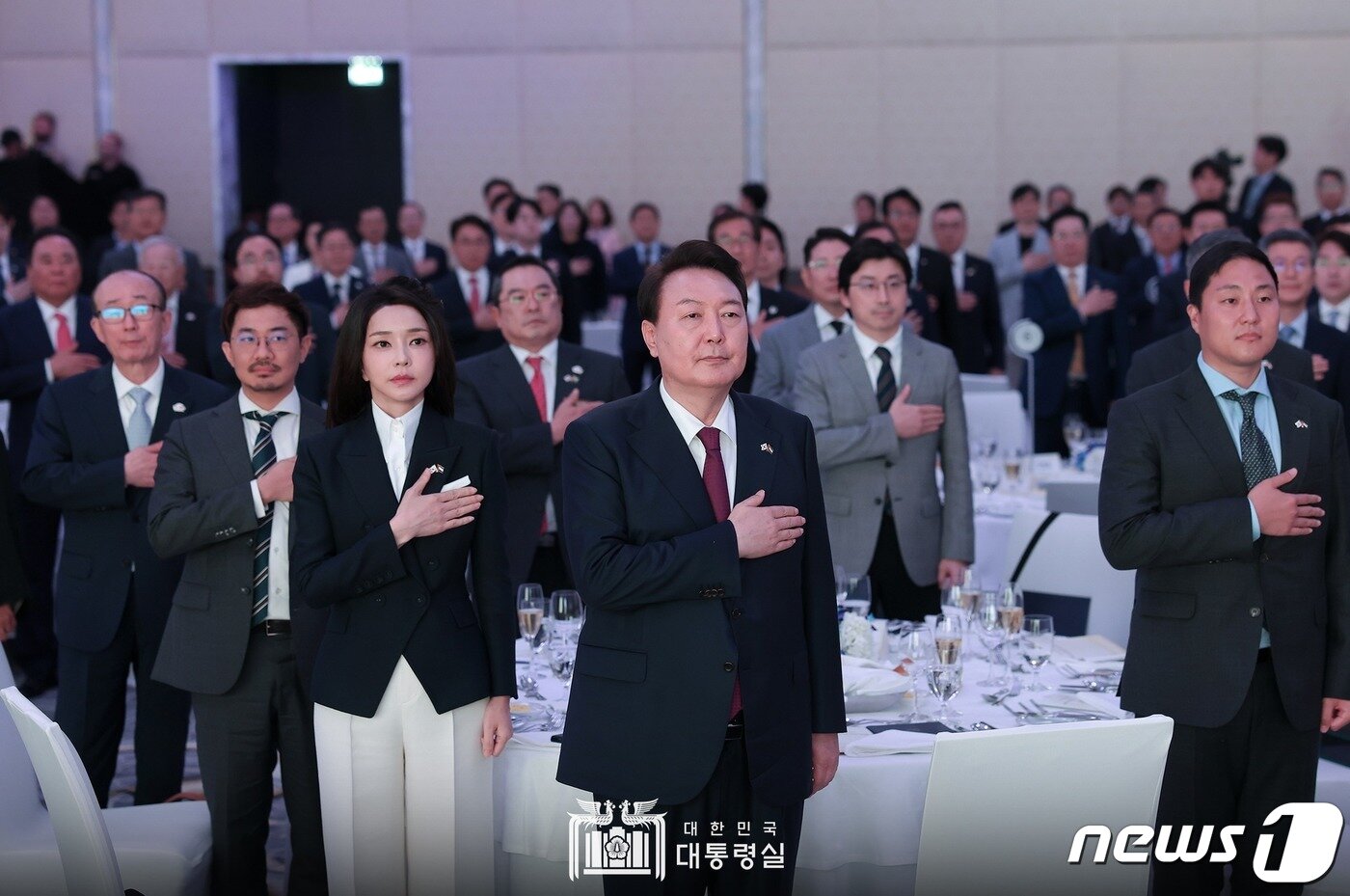 본문 이미지 - 윤석열 대통령과 김건희 여사가 16일 오후(현지시간) 아랍에미리트(UAE) 콘래드 아부다비 에티하드타워에서 열린 동행 경제인과의 만찬 간담회에서 참석자들과 국기에 대한 경례를 하고 있다. (대통령실 페이스북) 2023.1.17/뉴스1 ⓒ News1 안은나 기자