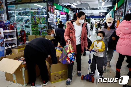 중국 베이징의 한 쇼핑몰에서 한 여성과 아이가 장난감을 분류하는 직원들을 지나쳐 걷고 있는 모습. © 로이터=뉴스1