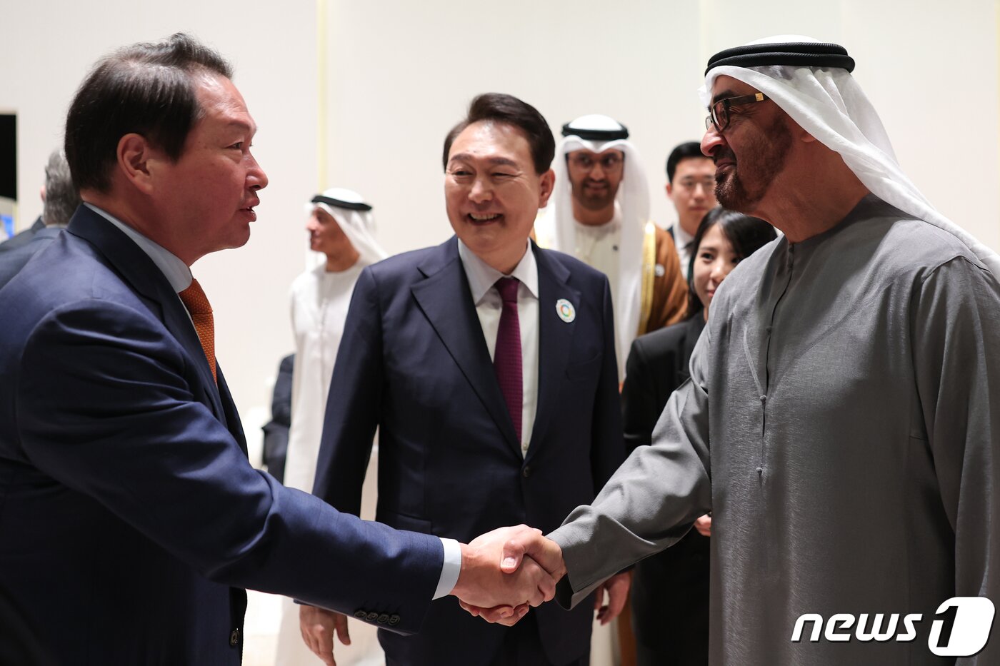 본문 이미지 - 최태원 대한상공회의소 회장이 16일 오전(현지시간) 아랍에미리트(UAE) 아부다비 국립전시장에서 열린 아부다비 지속가능성주간 개막식에 참석해 모하메드 빈 자이드 알 나하얀 UAE 대통령과 악수하고 있다. 가운데는 윤석열 대통령. (대통령실 제공) 2023.1.17/뉴스1 ⓒ News1 안은나 기자