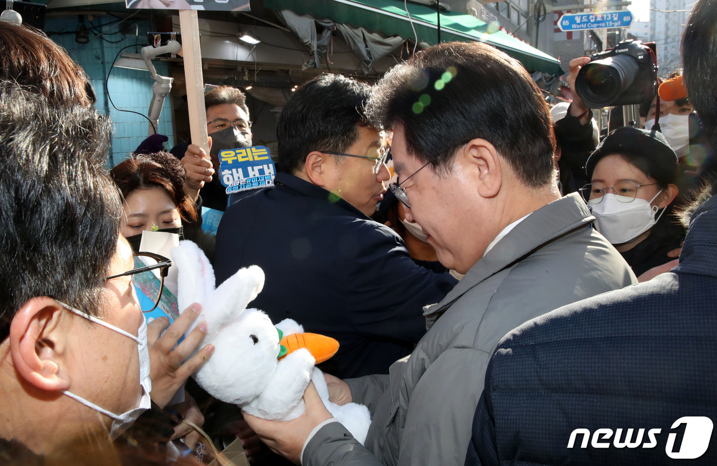 (서울=뉴스1) 이재명 기자 = 이재명 더불어민주당 대표가 설 명절을 앞두고 18일 오후 서울 마포구 망원시장을 방문해 지지자로부터 인형을 선물받고 있다. (공동취재) 2022.1 …