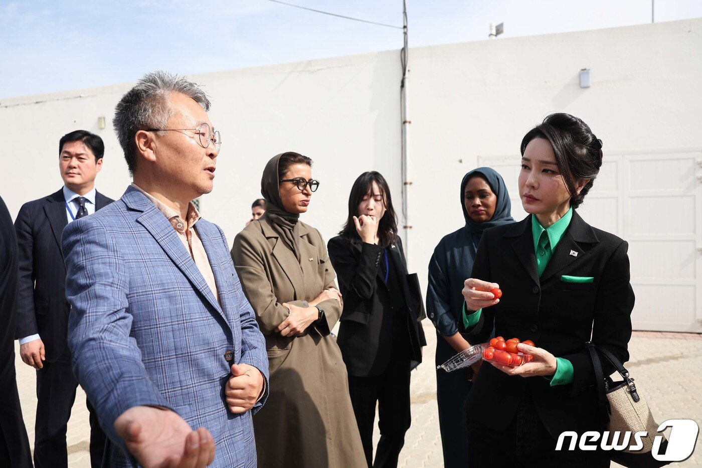 본문 이미지 - 윤석열 대통령 부인 김건희 여사가 17일(현지시간) 아랍에미리트(UAE) 두바이 현지의 스마트팜 진출기업인 아그로테크(AgroTech)를 찾아 관계자의 설명을 들으며 토마토를 시식하고 있다. (대통령실 제공) 2023.1.19/뉴스1 ⓒ News1 안은나 기자