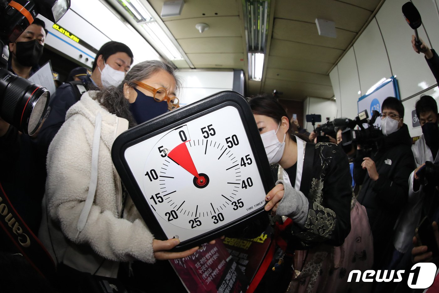 본문 이미지 - 전국장애인차별철폐연대(전장연) 회원들이 2일 오전 서울 삼각지역에서 장애인 권리 예산 확보를 위한 지하철 타기 선전전에 앞서 법원의 조정안을 수용한 5분 타이머를 맞추고 있다. 2023.1.2/뉴스1 ⓒ News1 이동해 기자