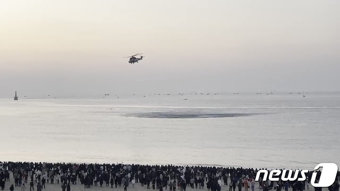 본문 이미지 - 2023년 계묘년(癸卯年) 첫날인 1일 오전 부산 해운대해수욕장 상공에 경찰이 헬기를 띄워 해맞이 인파 밀집도를 파악하고 있다.(부산경찰청 제공)  