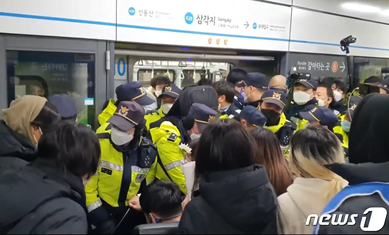 본문 이미지 - 전국장애인차별철폐연대(전장연) 활동가 등이 2일 오후 삼각지역 플랫폼(당고개·진접 방면)에서 지하철 탑승을 시도하며 12시간 동안 경찰·서울교통공사와 대치했다. 이로인해 4호선 당고개 방면 열차 13대가 삼각지역을 무정차 통과하기도 했다. (전장연 페이스북) 2023.1.2/뉴스1