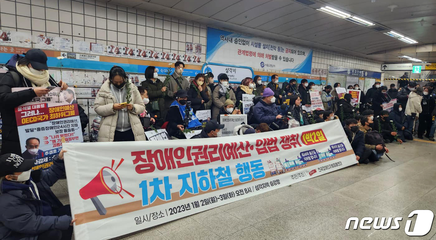 (서울=뉴스1) = 전국장애인차별철폐연대(전장연) 활동가 등이 2일 오후 삼각지역 플랫폼에서 12시간 동안 경찰·서울교통공사와 대치 끝에 고 우동민 활동가 추모 헌화로 장애인권리예 …