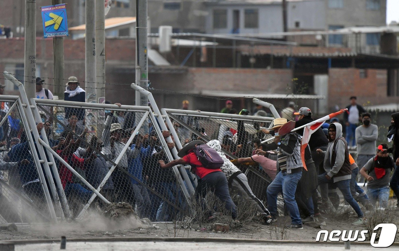 본문 이미지 - 19일(현지시간) 페루 아레키파 소재에서 페드로 카스티요 전 페루 대통령 탄핵에 불복한 시위대가 펜스를 넘어뜨리며 로드리게-발롱 국제공항 습격을 시도하고 있다. 2023.1.19. ⓒ AFP=뉴스1 ⓒ News1 김성식 기자