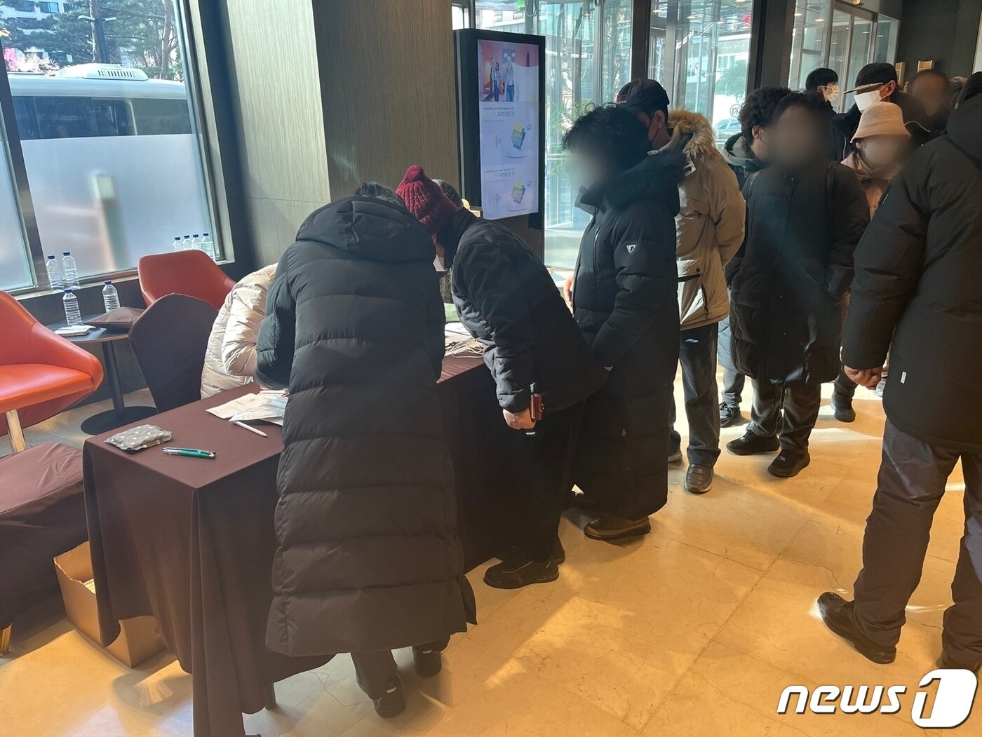 본문 이미지 - 강남구에서 마련한 임시거주 호텔에 도착해 입실카드를 받기 위해 대기 중인 구룡마을 이재민들. 이들 역시 넋이 나간 표정이었다. 2023.01.20./뉴스1 ⓒNews1 원태성 기자