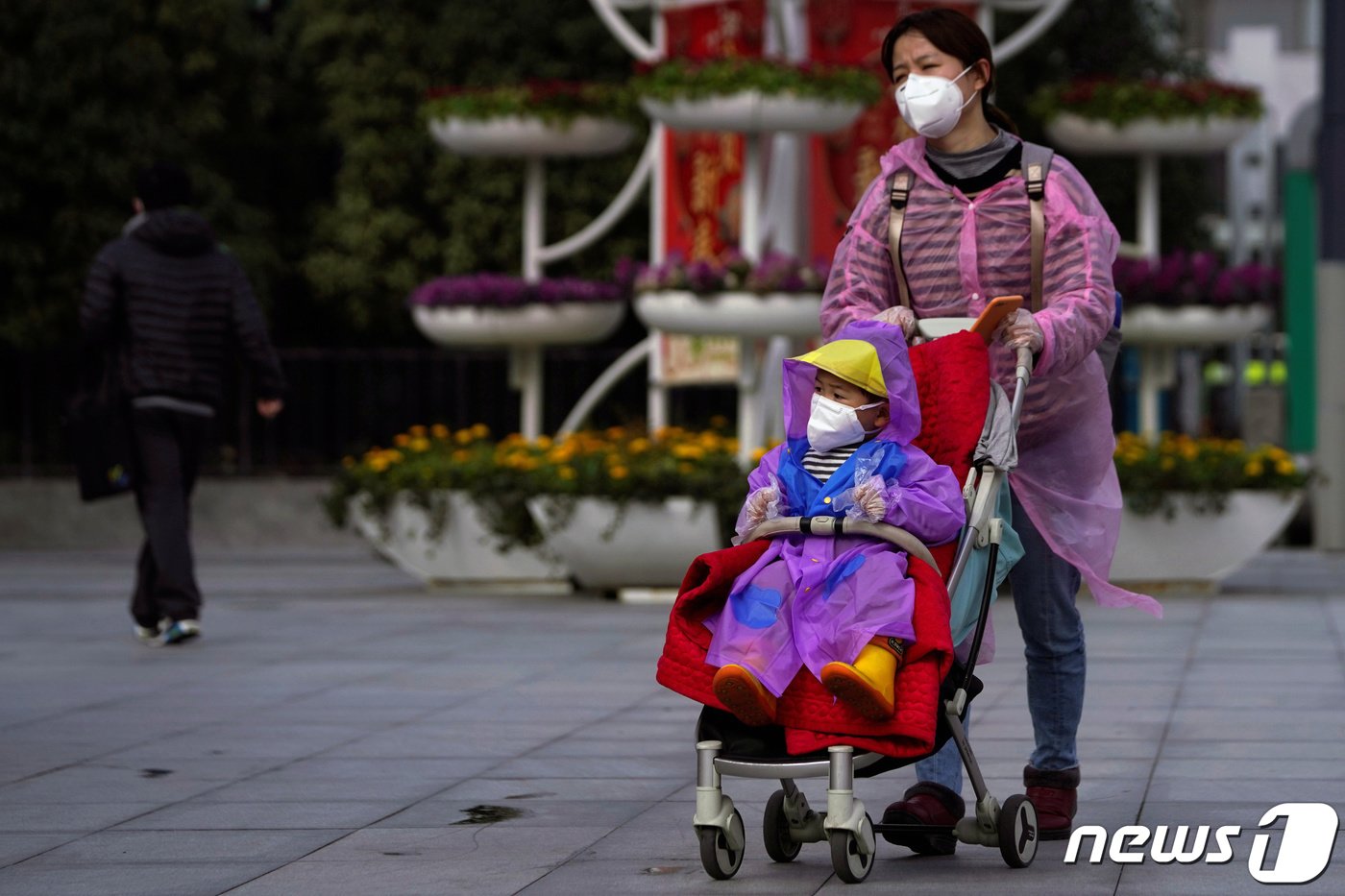 중국 상하이에서 한 여성이 아이와 마스크를 착용하며 길을 걷고 있다. 2020.02.13. ⓒ 로이터=뉴스1 ⓒ News1 정윤영 기자