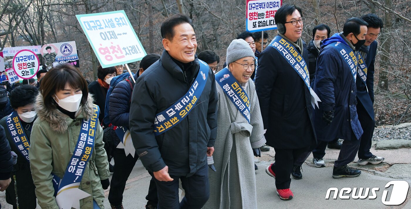 본문 이미지 - 최기문 영천시장(왼쪽 두번째)이 23일 팔공산 갓바위서 열린 '대구군부대 유치 기원행사'에 참석하기 위해 팔공산을 오르고 있다. (영천시 제공)2023.1.13/뉴스1 ⓒ News1 정우용 기자