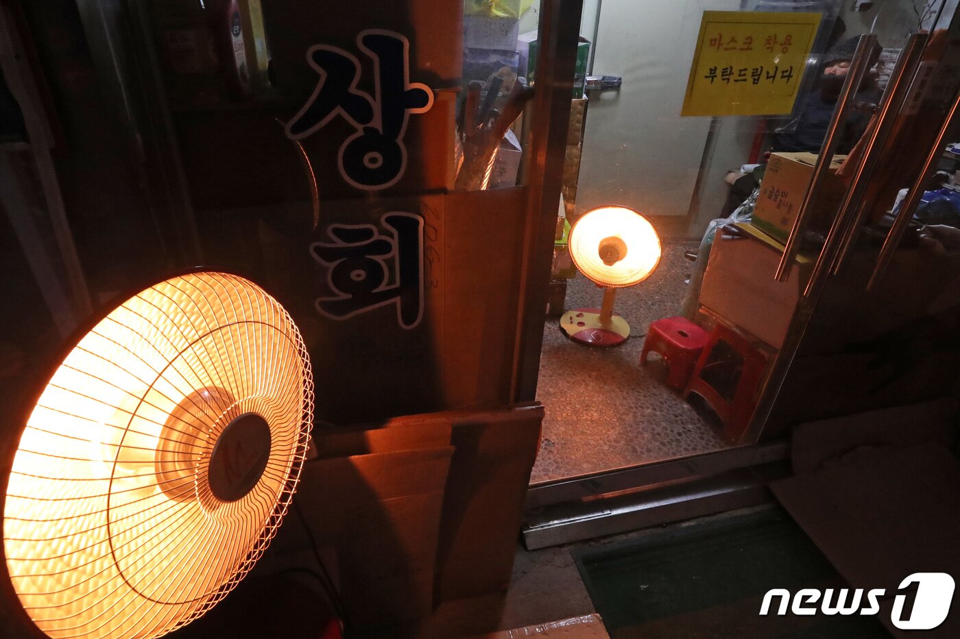 본문 이미지 - 전국에 한파 특보가 발효된 25일 서울 중구 합동시장에서 상인들이 온열기구를 곁에 두고 장사를 준비하고 있다. 2023.1.25/뉴스1 ⓒ News1 조태형 기자
