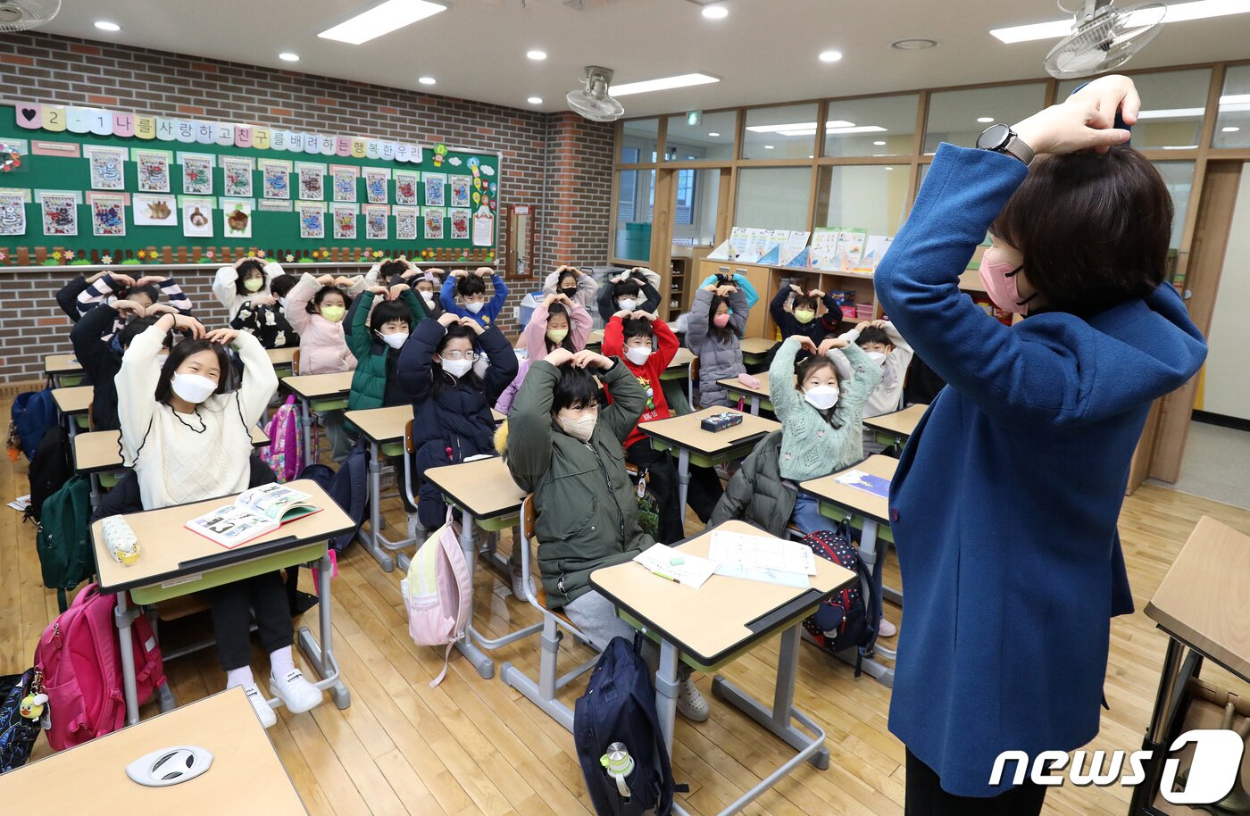본문 이미지 - 매서운 한파가 몰아친 25일 오전 겨울방학을 마치고 개학한 대구 수성구 동천초등학교 교실에서 학생들이 머리 위로 하트 모양을 만들어 보이며 선생님과 인사를 나누고 있다. 2023.1.25/뉴스1 ⓒ News1 공정식 기자