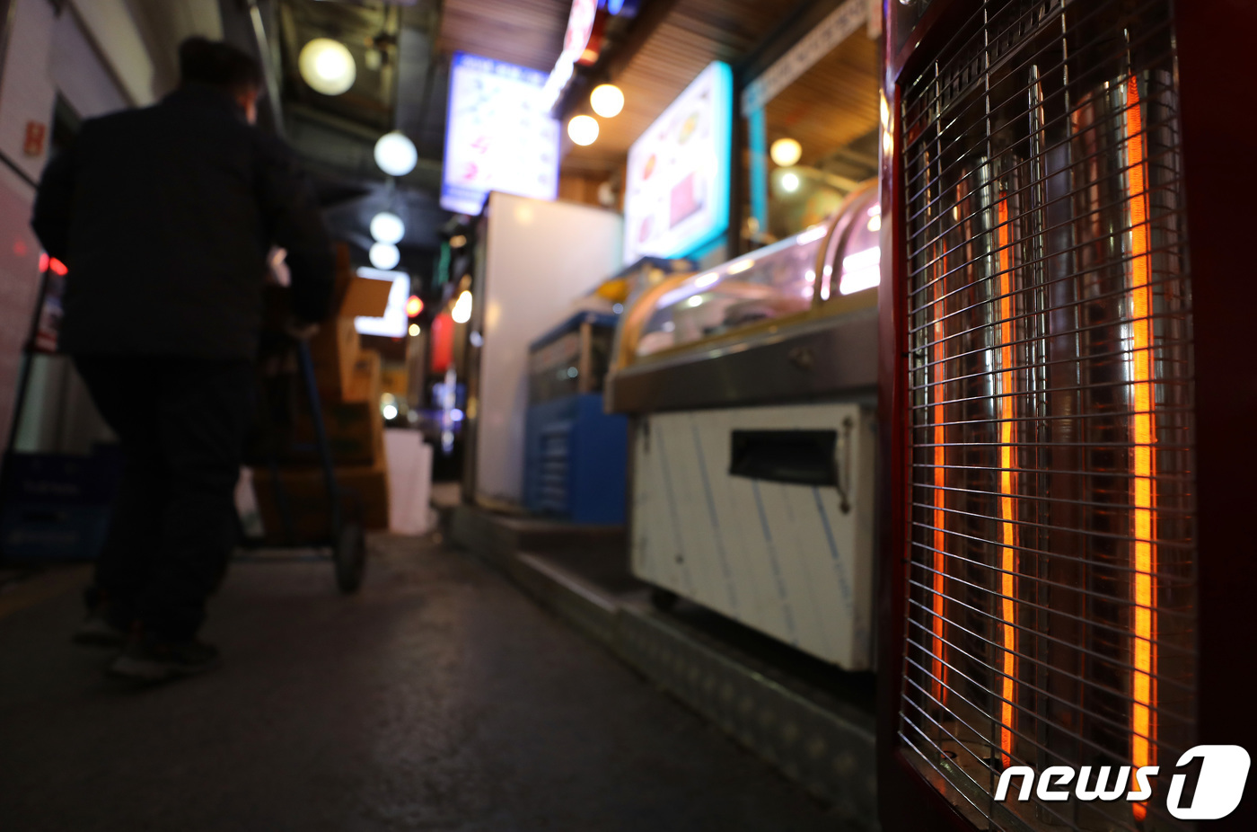 (서울=뉴스1) 이동해 기자 = 체감온도가 영하 20도 아래로 떨어지는 등 올겨울 가장 추운 날씨를 기록한 25일 서울의 한 전통시장 입구에 위치한 가게 앞에 난로가 놓여져 있다. …