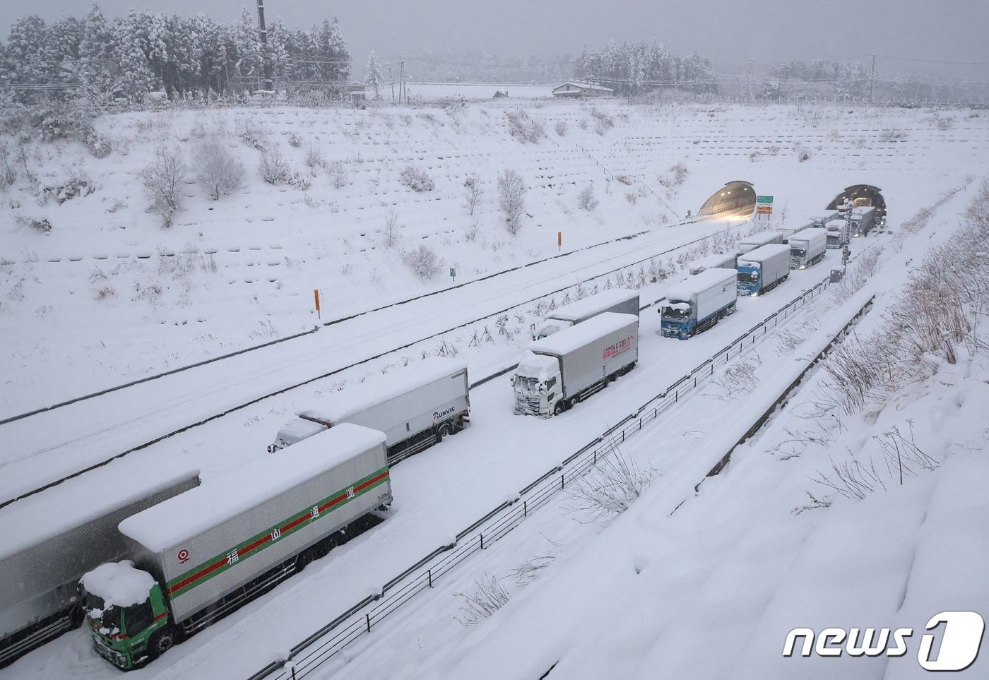 본문 이미지 - 25일 (현지시간) 기록적인 한파에 폭설이 내린 일본의 욧카이치 신메이신고속도로에 트럭들이 멈춰 있다. ⓒ AFP=뉴스1 ⓒ News1 우동명 기자