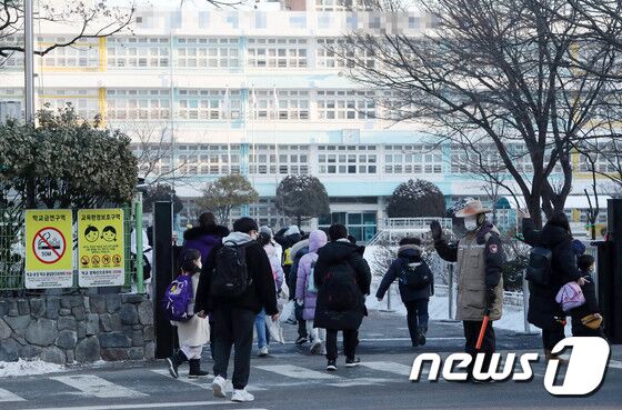 27일 서울시내 한 초등학교에서 학생들이 등교하고 있다. 교육부가 30일부터 학교 실내 마스크 착용을 의무에서 자율 착용으로 조정하기로 했다. 2023.1.27/뉴스1 © News1 박세연 기자