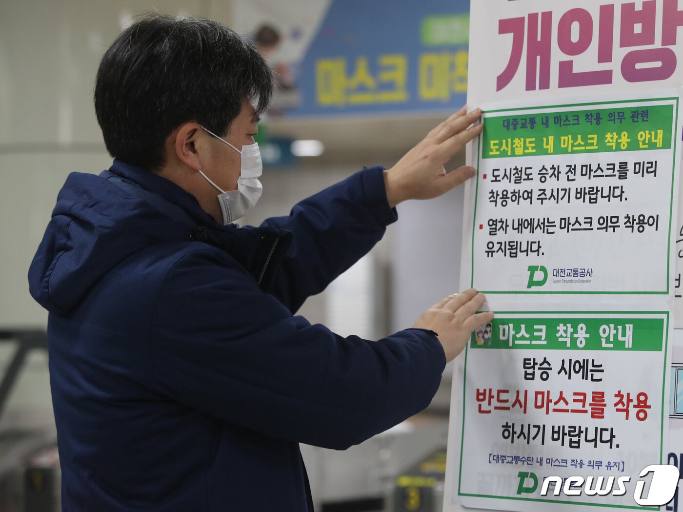 본문 이미지 - 실내에서 마스크 착용 의무 조치 해제를 하루 앞둔 29일 대전도시철도 1호선 정부청사역에서 관계자가 안내문을 붙이고 있다.  2023.1.29/뉴스1 ⓒ News1 김기태 기자