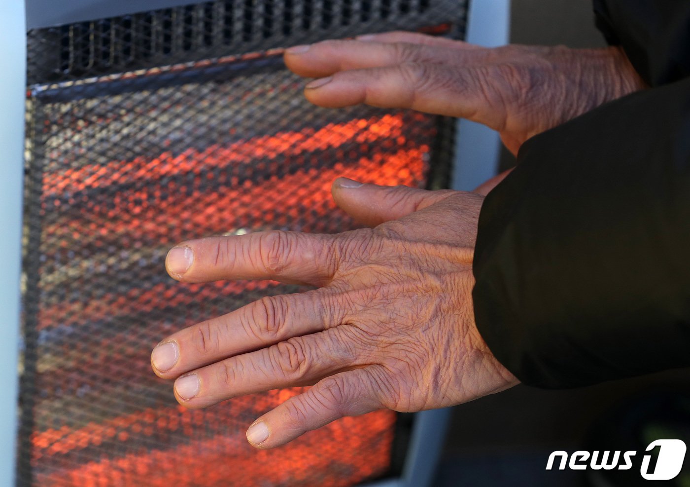 본문 이미지 - 서울 최저기온이 영하 9도까지 떨어지는 등 한파가 연일 계속되는 3일 서울 중구 남대문시장에서 한 상인이 난로에 언 손을 녹이고 있다. 2023.1.3/뉴스1 ⓒ News1 박세연 기자