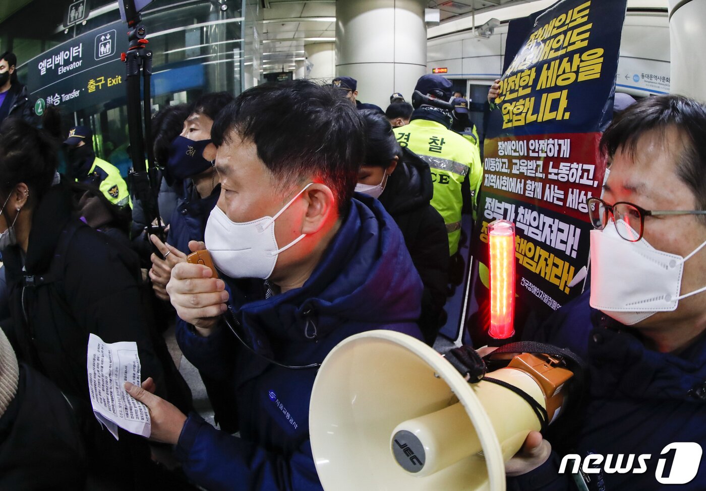 본문 이미지 - 3일 오전 서울 동대문역사공원역에서 역장이 전국장애인차별철폐연대(전장연) 활동가들을 제지하기 위해 안내방송 하고 있다. 전장연은 이날 오전 8시 성신여대역에서 기습 선전전을 진행했다. 2023.1.3/뉴스1 ⓒ News1 김도우 기자