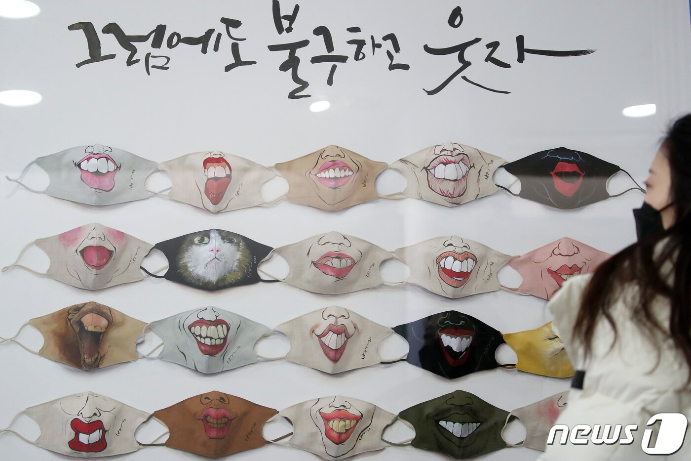 본문 이미지 - 실내 마스크 착용 의무가 해제된 30일 대구시청 동인청사에서 한 시민이 다양한 웃음을 마스크에 그려 넣은 미술작품 '그럼에도 불구하고 웃자(2021년 1월 손그림 정세벽·손글씨 송해영)'를 바라보고 있다.  2023.1.30/뉴스1 ⓒ News1 공정식 기자
