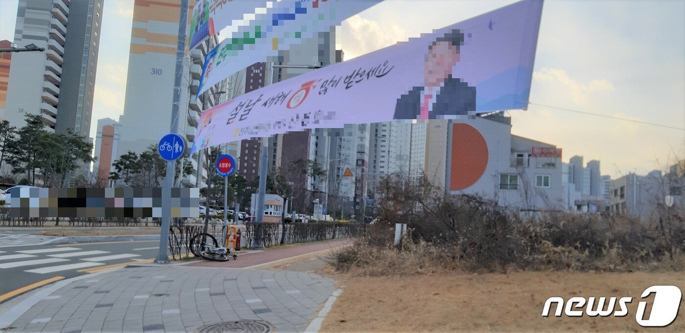 본문 이미지 - 진주의 한 농협이 조합장의 설 명절 인사와 사업 성과 홍보 등의 불법 현수막을 자전거도로를 가로질러 설치했다. 2023.1.28 뉴스1/한송학기자