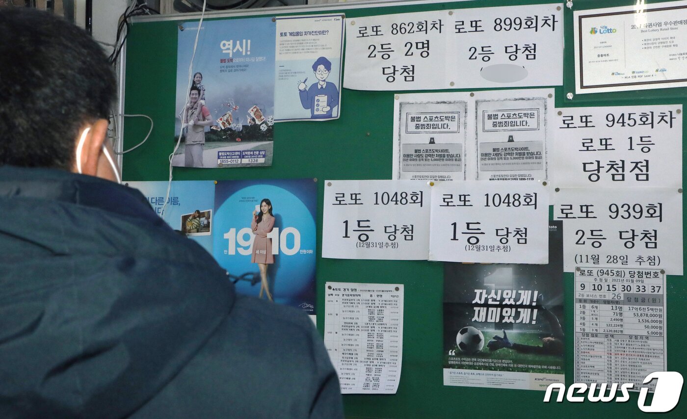 본문 이미지 - 지난 4일 오후 5시 광주 북구 문흥동에 위치한 로또명당 복권집에서 한 시민이 당첨 기록을 살펴보고 있다. 2023.1.5/뉴스1 ⓒ News1 이수민 기자
