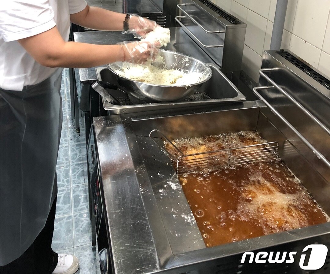 본문 이미지 - 물반죽과 파우더를 묻힌 닭 조각을 기름에 넣는다. ⓒ News1 윤슬빈 기자