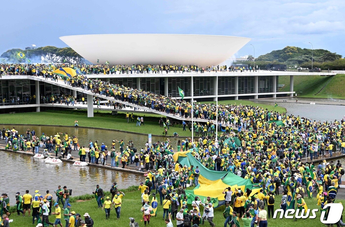 본문 이미지 - 8일(현지시간) 브라질 브라질리아 의회 의사당 앞에서 자이르 보우소나루 전 브라질 대통령 지지자들이 1일 임기를 시작한 루이스 이나시우 룰라 다 시우바 대통령에 반대하는 '대선 불복' 시위를 벌이며 의회를 습격하고 있다. 2023.1.8. ⓒ AFP=뉴스1 ⓒ News1 김성식 기자