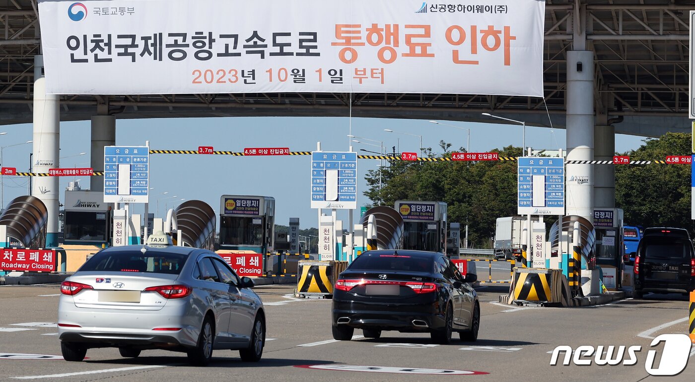 본문 이미지 - 인천 영종·인천대교를 이용하는 지역주민들에 대한 통행료 무료화 및 인천국제공항고속도로 통행료 인하가 시행된 1일 오전 인천공항고속도로 톨게이트에 통행료 인하 플래카드가 걸려 있다.2023.10.1/뉴스1 ⓒ News1 박정호 기자