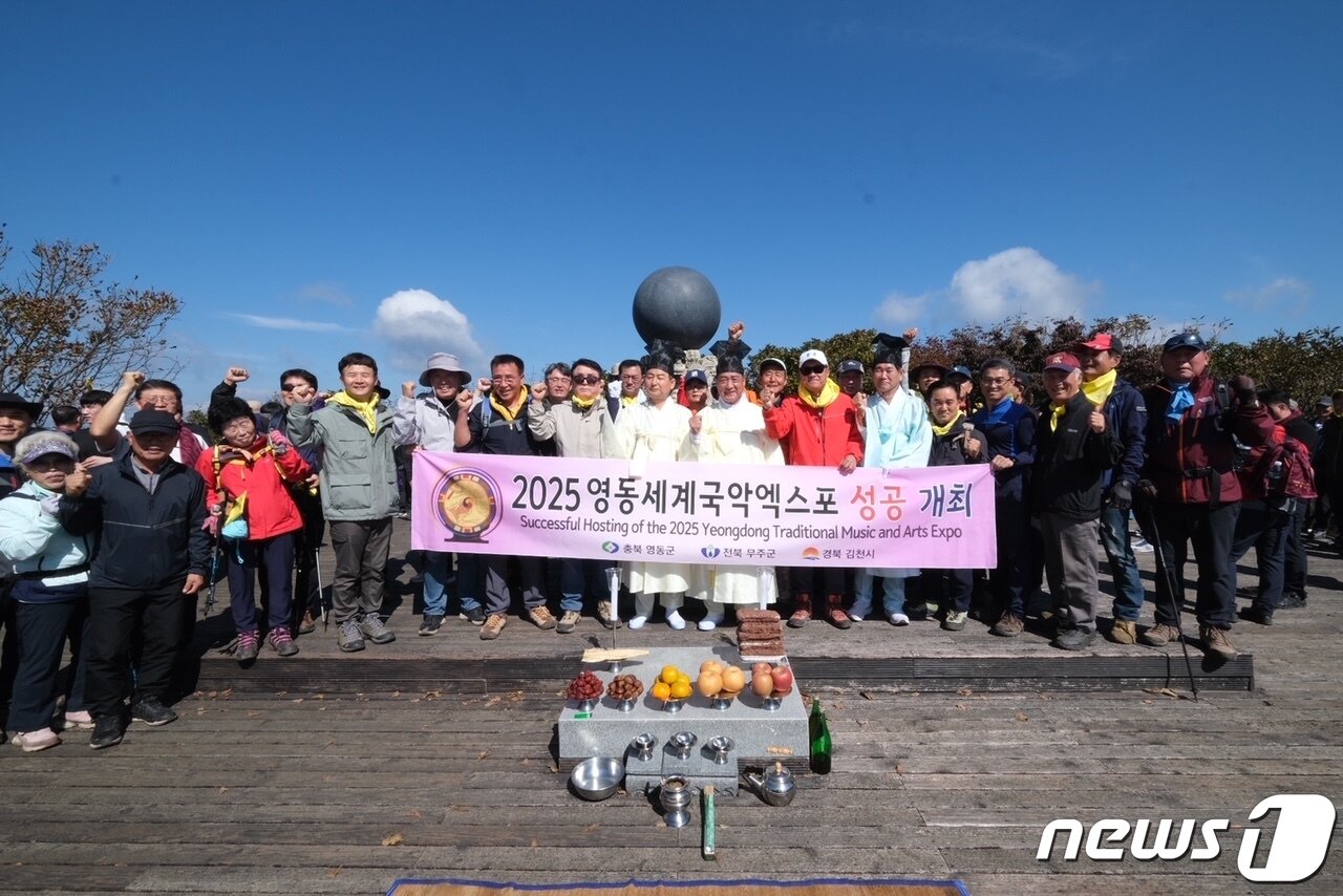 본문 이미지 - 10일 영동문화원이 주관한 삼도봉 '만남의 날' 행사에 참석한 3도 3시·군 주민들이 영동세계국악엑스포 성공 개최를 기원하며 파이팅하고 있다.(영동군 제공) /뉴스1
