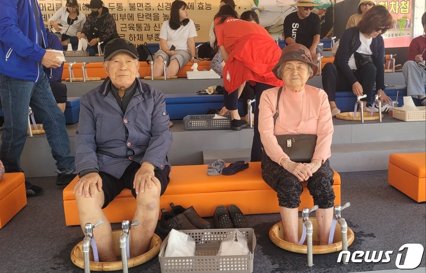 본문 이미지 - 천안에서 축제장을 찾은 유익환옹과 이계하옹 부부가 홍삼족욕을 즐기고 있다./ 뉴스1 