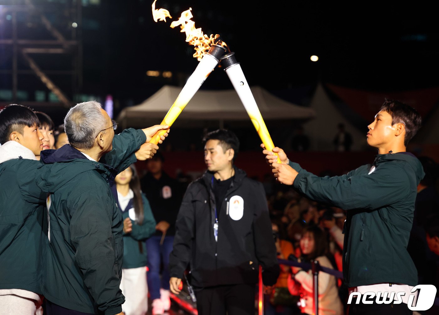 본문 이미지 - 유인촌 문화체육관광부 장관이 11일 서울 중구 서울광장에서 열린 2024강원동계청소년올림픽 G-100 기념행사에서 성화투어에 참여해 홍보대사 윤성빈 선수에게 성화를 인계하고 있다. (문화체육관광부 제공)