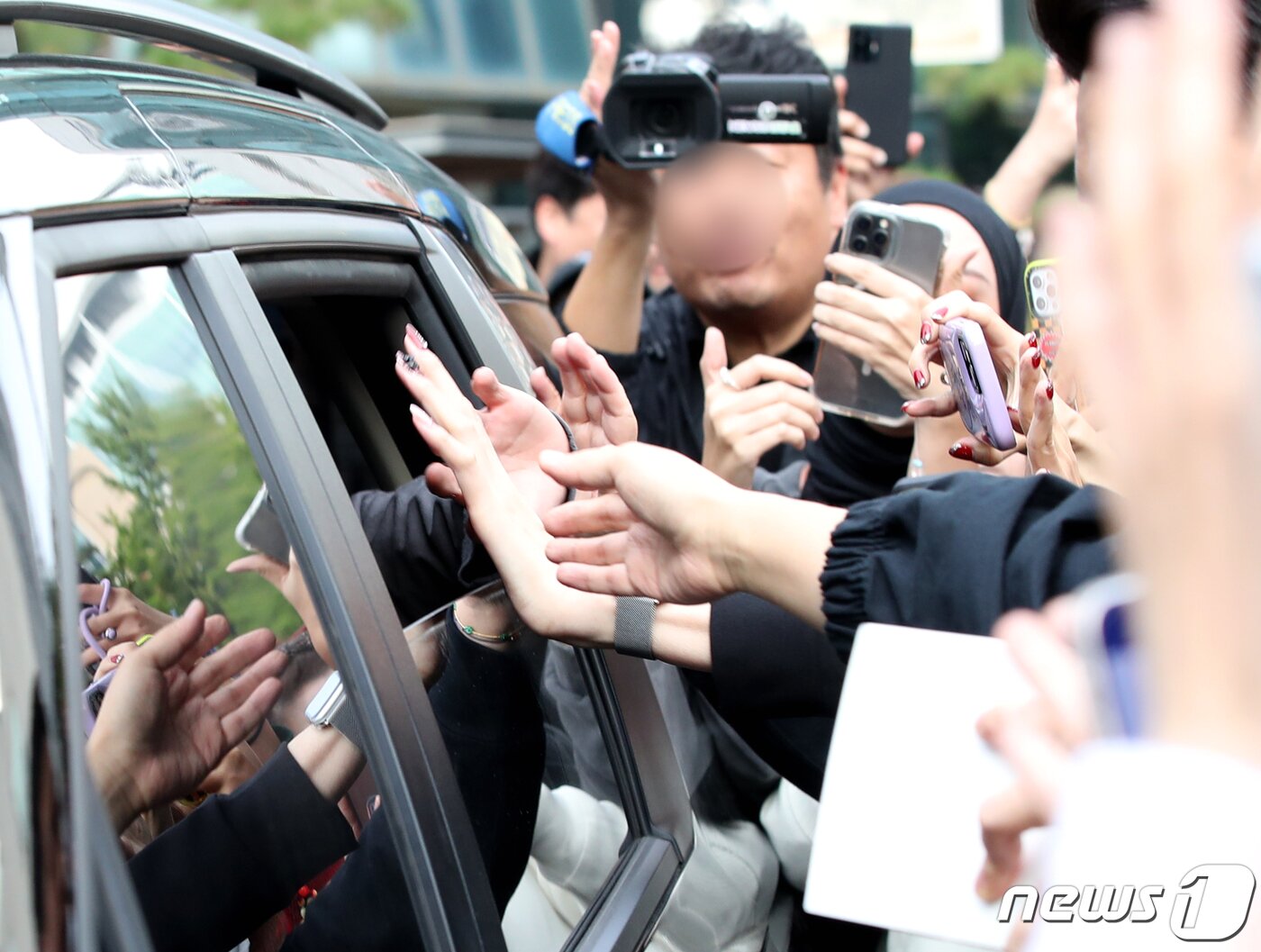 본문 이미지 - 방탄소년단 정국이 13일 오전 서울 여의도 KBS 신관에서 진행된 '뮤직뱅크' 녹화를 마친 뒤  팬과 손터치로 인사를 전하며 이동하고 있다. ⓒ News1 권현진 기자