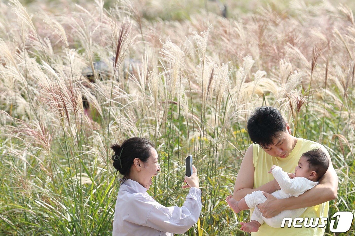 본문 이미지 - 15일 서울 마포구 하늘공원에서 열린 서울억새축제에서 한 부부가 아이와 함께 추억을 남기고 있다. 이번 억새축제에는 오는 20일까지 열리며 축제 기간 중에는 오후 10시까지 하늘공원을 개방한다. 2023.10.15/뉴스1 ⓒ News1 신웅수 기자