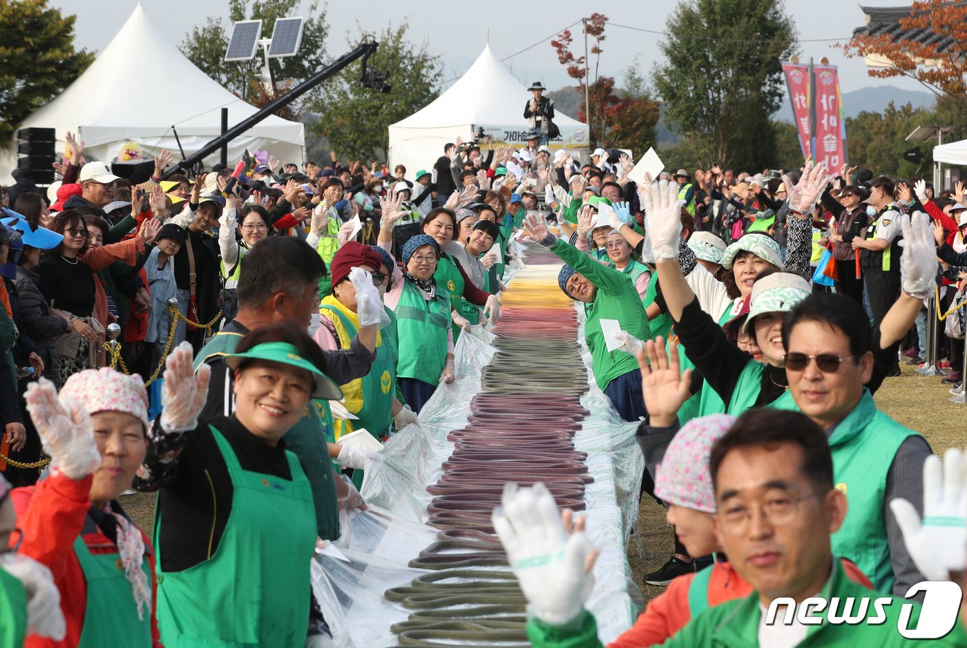 지난해 ‘제22회 이천쌀문화축제’가 개막한 18일 오후 경기 이천시 모가면 이천농업테마공원에서 행사 관계자들이 600m 가래떡을 만들고 기념촬영을 하고 있다. 2023.10.18/뉴스1 ⓒ News1 김영운 기자