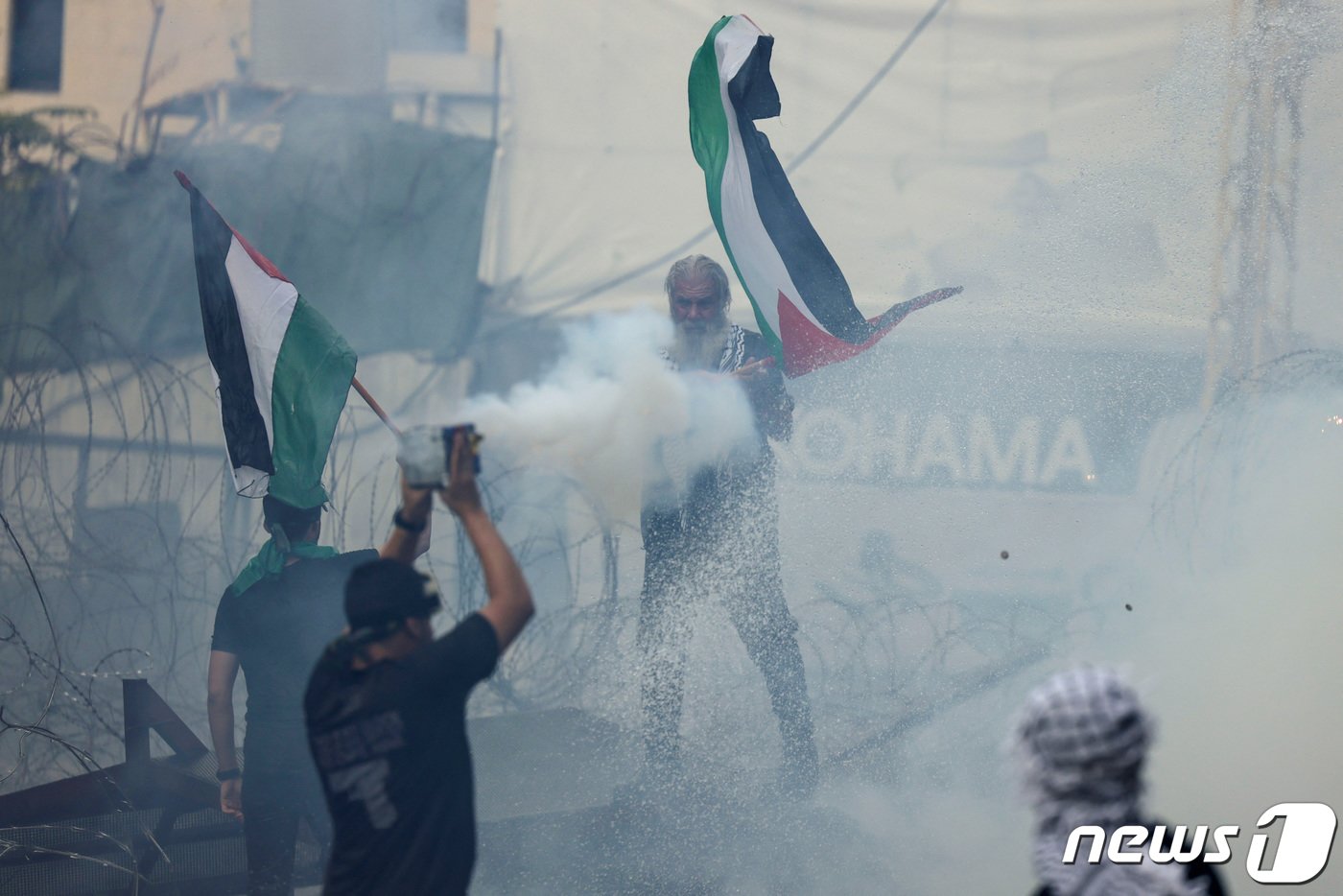 본문 이미지 - 18일(현지시간) 레바논 아카르에 있는 미국 대사관에서 시위대가 팔레스타인 국기를 들고 있다. 2023.10.19 ⓒ 로이터=뉴스1 ⓒ News1 정지윤 기자